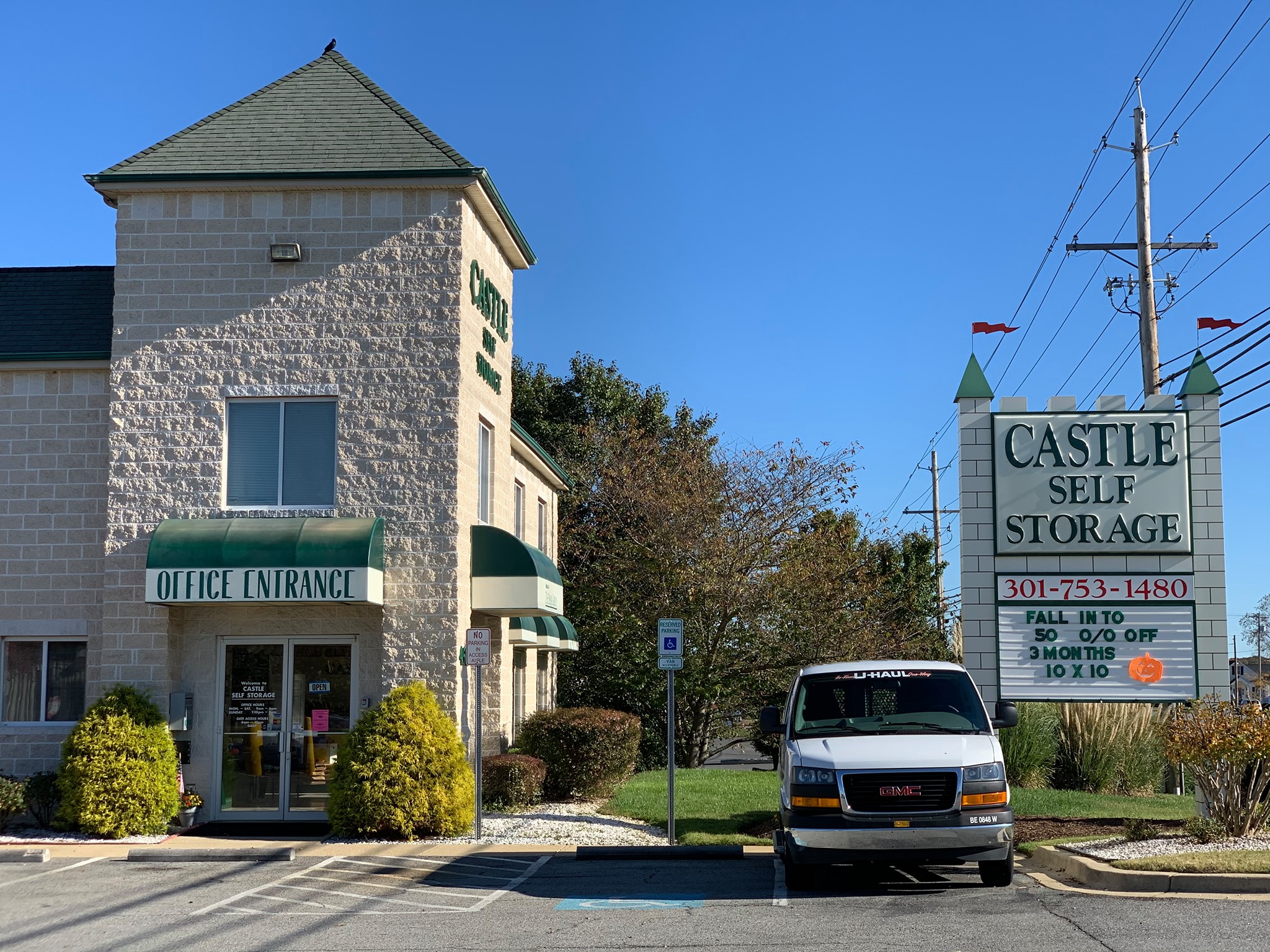 Self storage facility with a rental truck in the parking lot and a s sign that reads: "Castle Self Storage 301-753-1480"